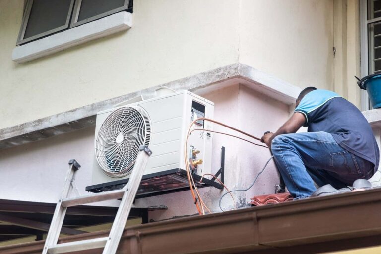 Professional technician servicing indoor split system air conditioner unit during maintenance appointment in Moreton Bay